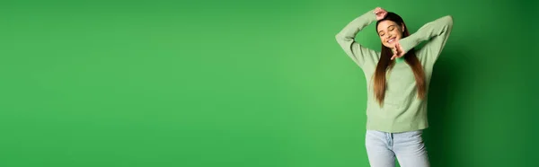 Щаслива дівчина-підліток в джинсах і джинсах позує на зеленому тлі, банер — Stock Photo