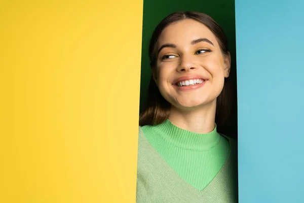 Smiling teenager in jumper looking away on colorful background — Stock Photo