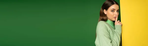 Young teen girl in jumper showing secret sign on colorful background, banner — Stock Photo