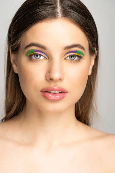Brunette teen girl with creative makeup looking at camera isolated on grey — Stock Photo