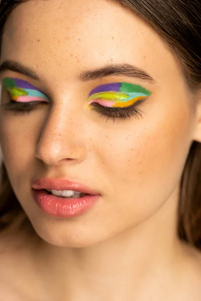 Portrait of freckled teenager with colorful eyeshadows isolated on grey — Stock Photo