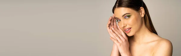 Teen girl with naked shoulder and colorful visage posing isolated on grey, banner — Stock Photo