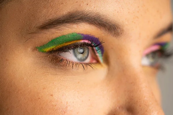 Cropped view of teen girl with freckles and colorful eyeshadows isolated on grey — Stock Photo