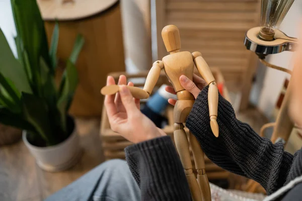 Cropped view of artist holding wooden doll in workshop — Stock Photo
