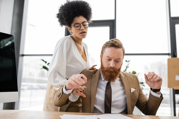 Curly african american businesswoman seducing bearded and tensed coworker — Stock Photo