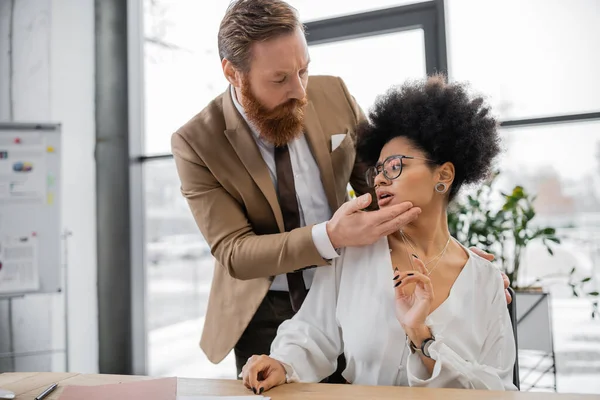 Bearded businessman seducing curly african american woman in office — Stock Photo