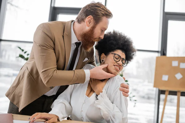 Bearded businessman seducing scared african american woman in office — Stock Photo
