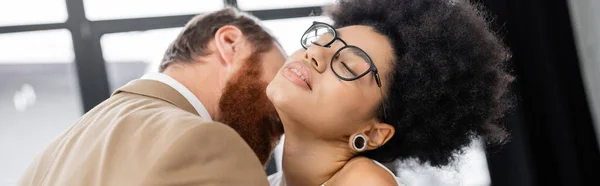 Bearded man kissing neck of seductive african american woman with closed eyes, banner — Stock Photo
