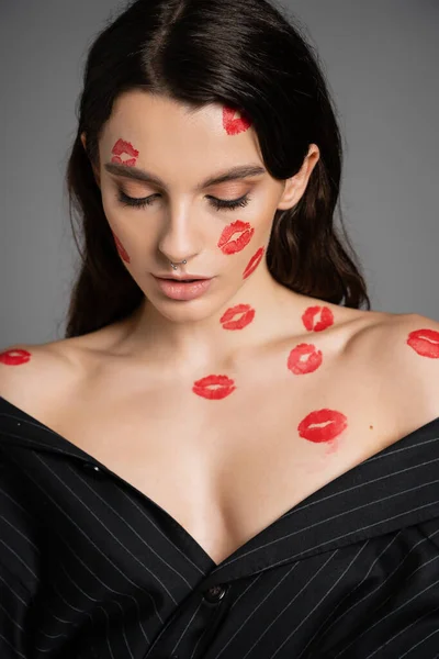 Portrait of pretty and sexy woman in red lip prints of face and body isolated on grey - foto de stock