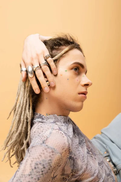 Stylish nonbinary person with silver rings on fingers isolated on yellow — Stockfoto