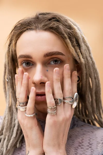 Portrait of queer person with rings on fingers looking at camera isolated on yellow - foto de stock