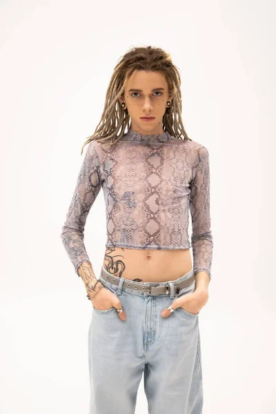 Tattooed queer person in crop top and jeans looking at camera isolated on white — Stock Photo
