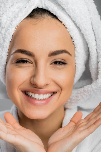 Portrait of positive woman with perfect skin and towel on head isolated on grey — стоковое фото