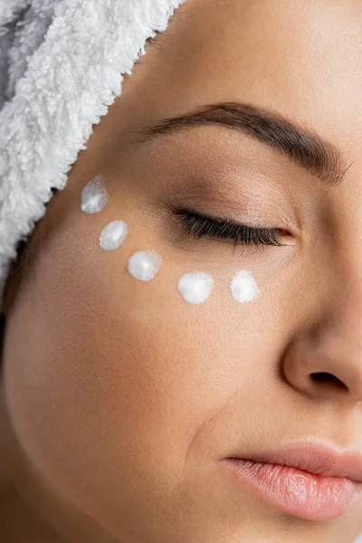 Close up view of woman with towel on head and face cream — Stock Photo
