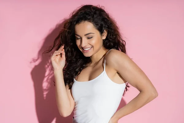 Positive young woman in top closing eyes on pink background — Stock Photo