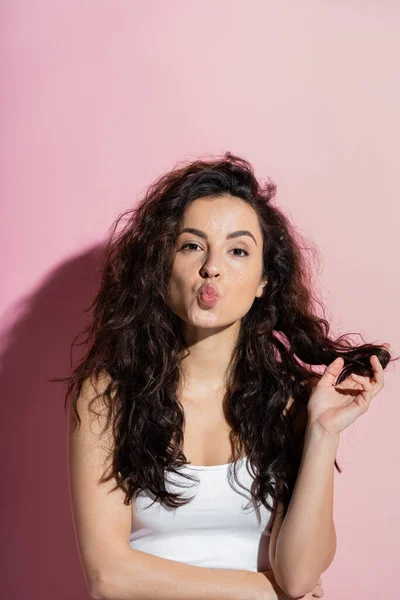 Young freckled woman pouting lips on pink background — Fotografia de Stock