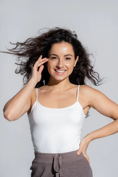 Smiling freckled woman posing and looking at camera isolated on grey — Stock Photo