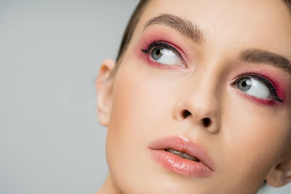 Close up portrait of pretty woman with perfect skin and makeup looking away isolated on grey — Stock Photo