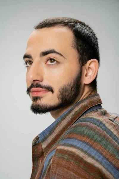 Portrait of good looking bearded man in colorful shirt looking away isolated on grey — Stock Photo