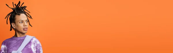 Multiracial man in trendy t-shirt looking away isolated on orange, banner — Stock Photo
