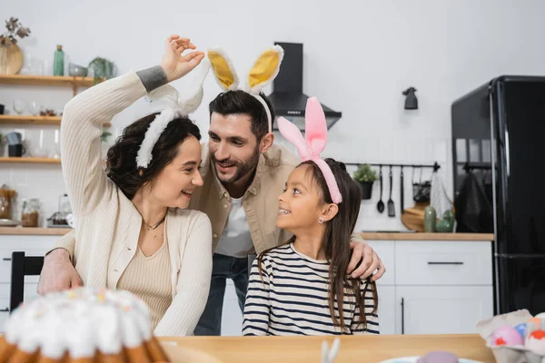 Sorrindo homem abraçando filha e esposa na Páscoa headbands em casa — Fotografia de Stock