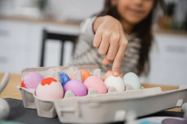 Vue recadrée d'un enfant flou touchant un œuf de Pâques à la maison — Photo de stock