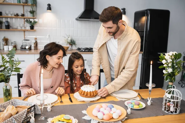Man cutting Easter bread near wife and daughter at home — Stock Photo