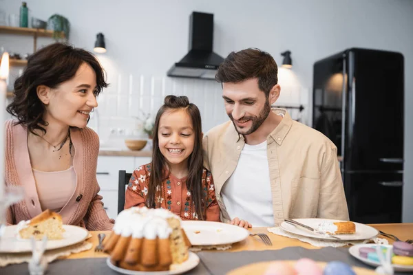 Smiling family with daughter having Easter dinner in kitchen — Stock Photo