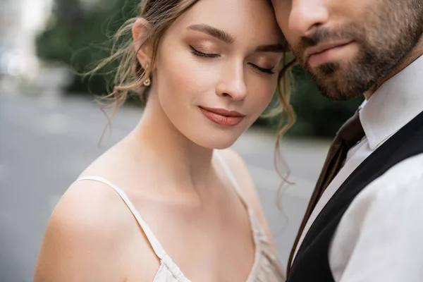Portrait of sensual bride and bearded groom in vest with tie — Stock Photo