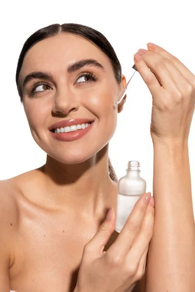 Smiling woman holding dropper with vitamin c serum isolated on white — Stock Photo