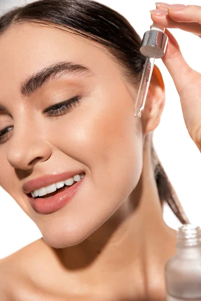Close up of happy young woman holding dropper with vitamin c serum isolated on white — Stock Photo