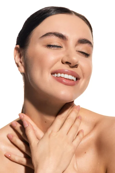 Mujer complacida con los ojos cerrados y maquillaje impecable aislado en blanco - foto de stock