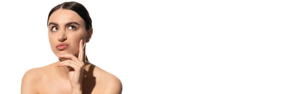 Pensive woman with bare shoulders and flawless makeup pouting lips isolated on white, banner — Stock Photo