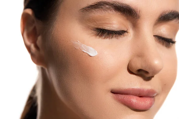 Close up view of young woman with face cream on cheek isolated on white — Stock Photo