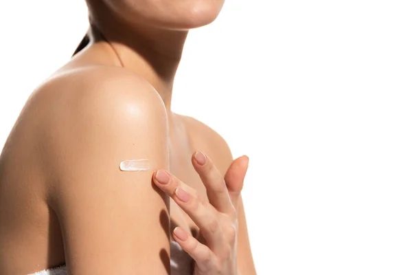 Cropped view of young woman applying lotion on body isolated on white — Stock Photo