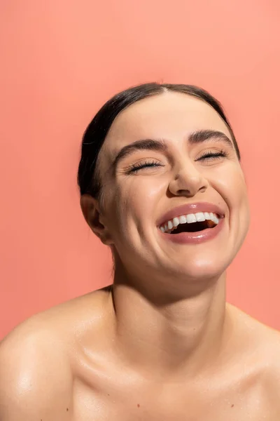 Portrait of happy young woman with bare shoulders laughing isolated on pink — Stock Photo