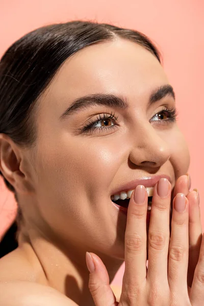 Gros plan de femme excitée avec la bouche ouverte riant tout en regardant loin isolé sur rose — Photo de stock