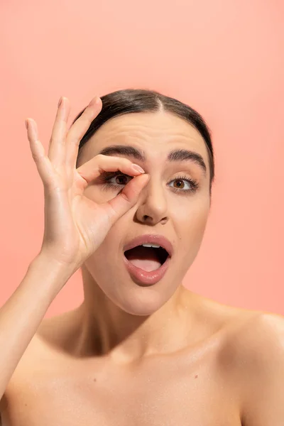 Amazed woman with opened mouth showing ok sign isolated on pink — Stock Photo