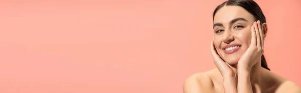 Encantadora joven con hombros desnudos mirando a la cámara mientras sonríe aislada en rosa, pancarta — Stock Photo