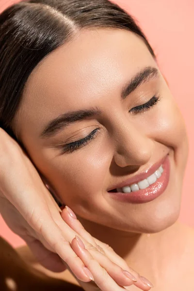 Close up view of satisfied woman with clenched hands and closed eyes isolated on pink — Stock Photo