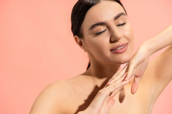 Charming woman with clenched hands and closed eyes posing isolated on pink — Stock Photo