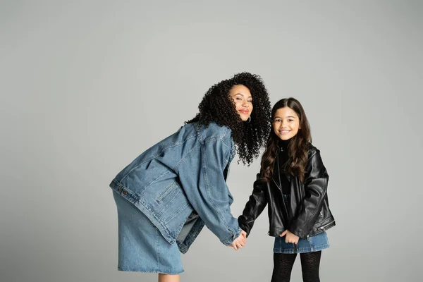 Trendy mother and daughter holding hands isolated on grey — Foto stock