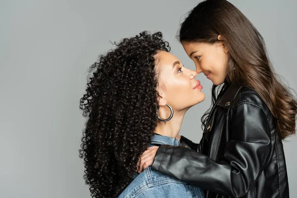 Side view of stylish mom and kid standing nose to nose isolated on grey — Stock Photo