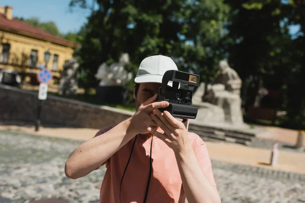 Young traveler with vintage camera taking photo on Andrews descent in Kyiv — Stock Photo