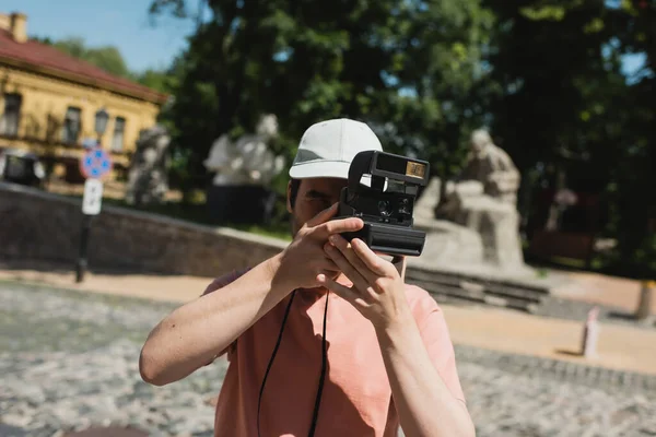 Joven viajero con cámara vintage tomando fotos en el descenso de Andrews en Kiev - foto de stock