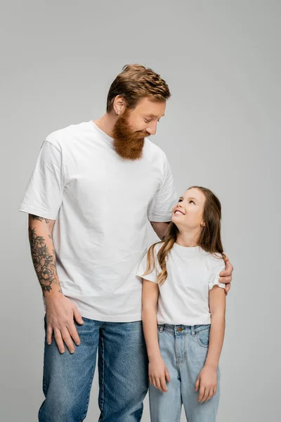 Татуированный отец обнимает дочь-подростка, изолированную от серых — стоковое фото