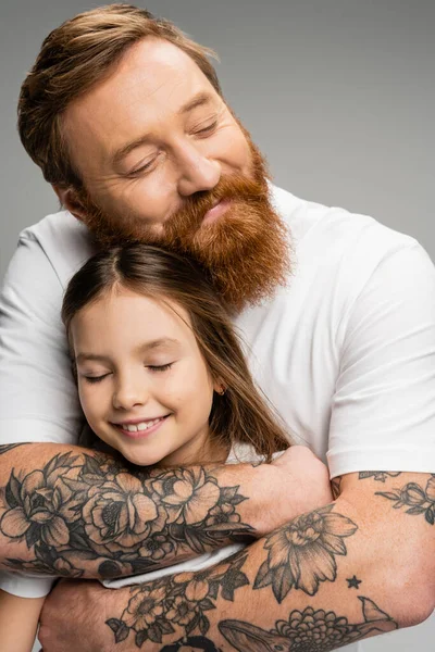 Joyeux tatoué père étreignant fille préadolescente isolé sur gris — Photo de stock
