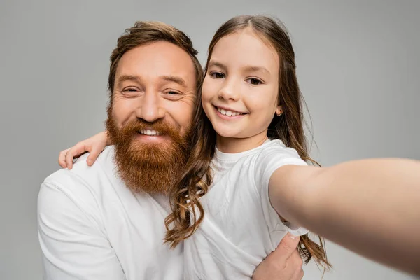Smiling preteen kid hugging bearded dad in white t-shirt isolated on grey — Stock Photo