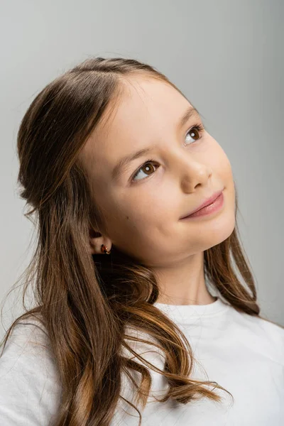 Dreamy preteen child looking away isolated on grey — Stock Photo