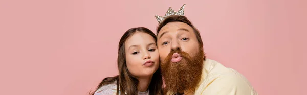 Бородатый мужчина с головной убор надутые губы рядом с дочерью изолированы на розовый, баннер — стоковое фото